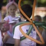 Photo of the back of a boy wearing butterfly wings made out of balloons