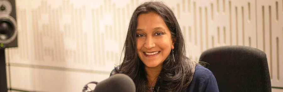 Sharmila Collins sitting in a radio studio in front of a microphone
